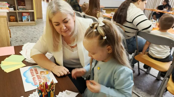 Библиотекарь  с детьми делают открытку