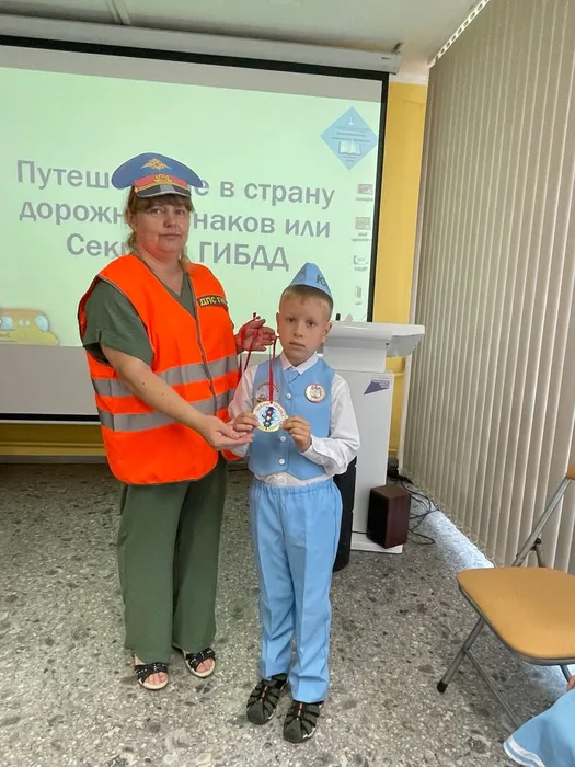 Сотрудник в образе Инспектора вручает медаль за Знание ПДД — копия