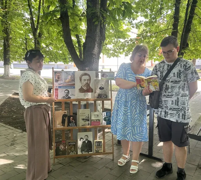 Библиотекарь рассказывает прохожим о творчестве писателя