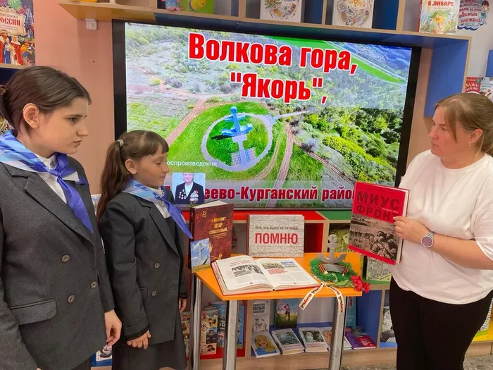 Библиотекарь знакомит ребят с книгами представленными на книжной выставке