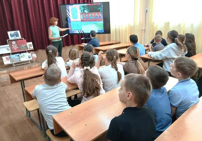 Сотрудник библиотеки показывает памятник Герою