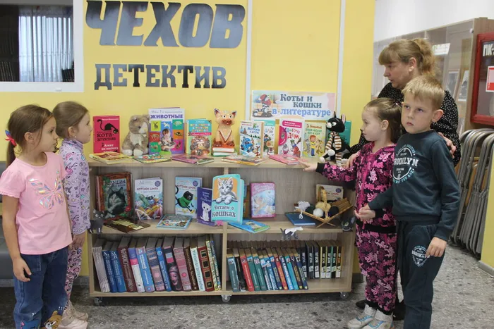 Библиотекарь знакомит детей с книжной выставкой
