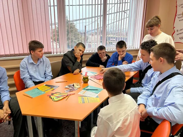 дети играют  в игру о доходах и расходах семьи