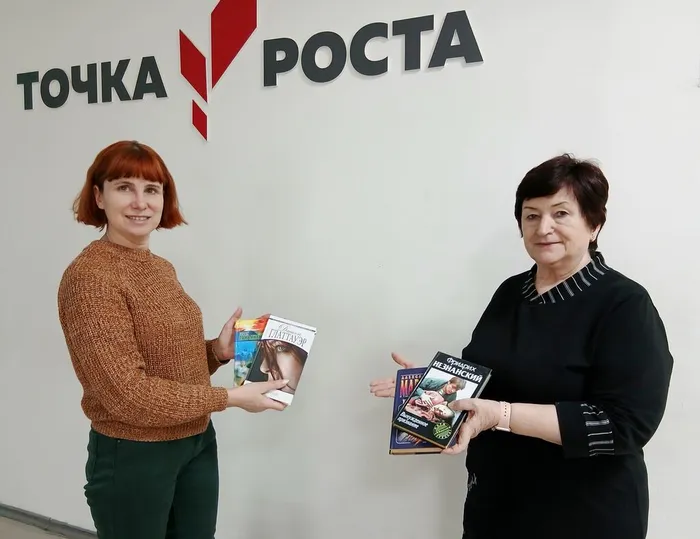 Сотрудник библиотеки принемает в дар книги