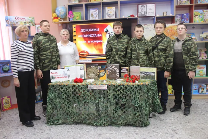 Участники мероприятия у книжной выставки Имя подвига Афганистан